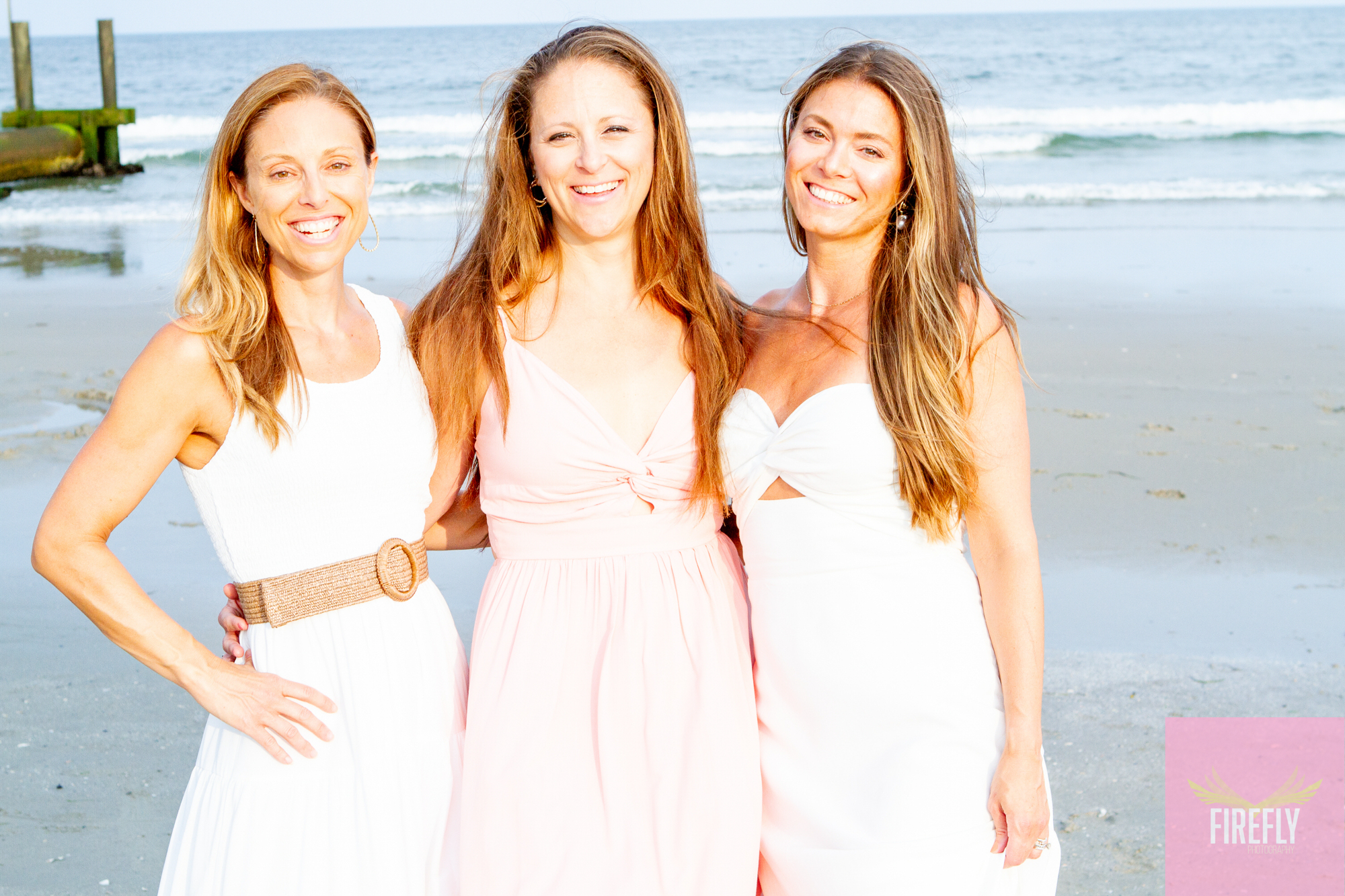 Three friends laughing on the beach